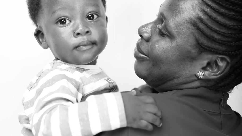 Bébé dans les bras d’une adulte qui prend soin de lui avec douceur