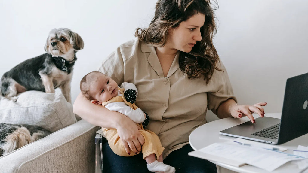 Mère avec son bébé travaillant sur un ordinateur portable à domicile