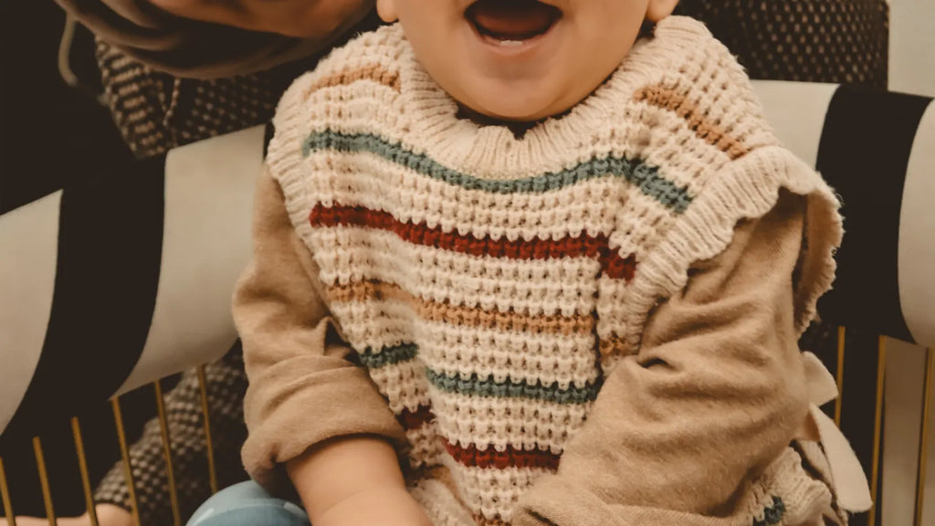 Bébé souriant avec sa mère dans un intérieur lumineux pendant la période des premières dents