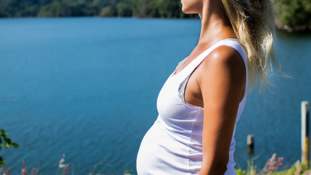 Femme enceinte lors d’un déplacement extérieur, illustrant la préparation d’un voyage pendant la grossesse